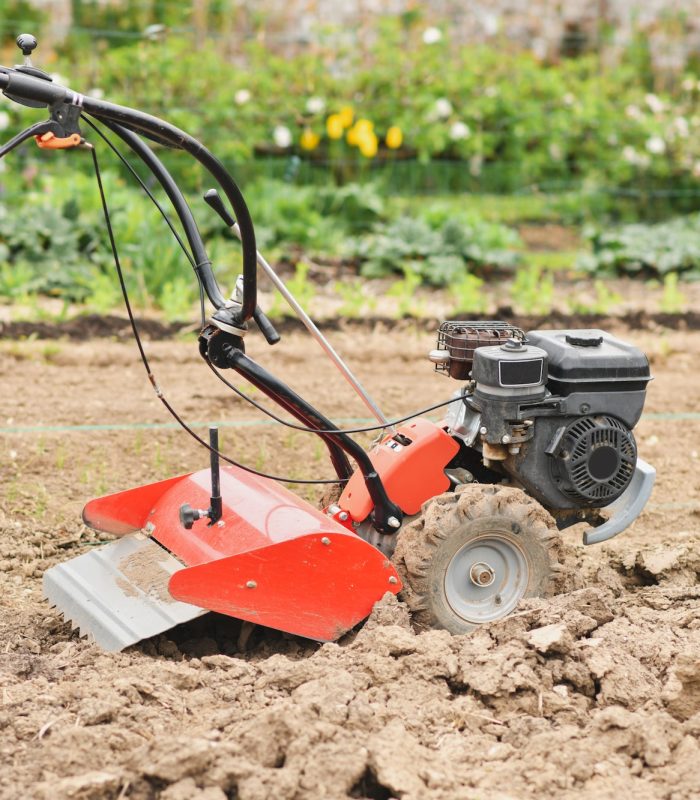 A plow plows the ground in the garden